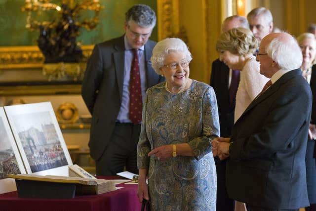 Queen Elizabeth II accompanies Mr Higgins as he is shown Irish-related items from the Royal Collection at Windsor Castle during the first state visit to the UK by an Irish president