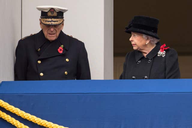 The Queen looks at her husband the Duke of Edinburgh, as they stand together on a balcony of the Foreign Office overlooking the annual Remembrance Sunday Service at the Cenotaph memorial in Whitehall, central London (Dominic Lipinksi/PA)
