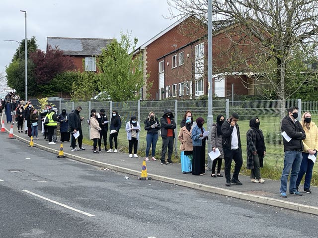 People queue for the vaccination centre at the Essa Academy in Bolton (PA Video/PA)