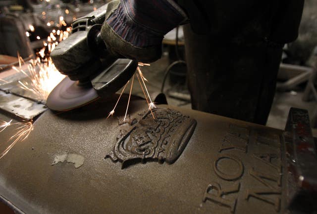 A Scottish Royal Mail pillar box being built using a metal grinder