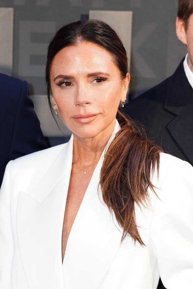 Victoria Beckham in a white suit jacket with a side ponytail