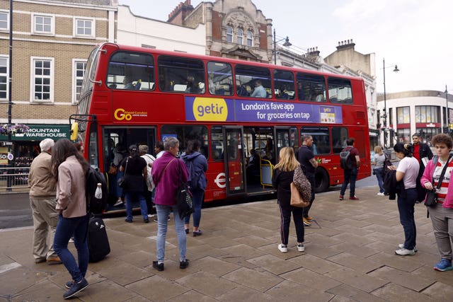 Passengers queue for a bus in Wimbledon, as train services continue to be disrupted following the nationwide strike by members of the Rail, Maritime and Transport union in a bitter dispute over pay, jobs and conditions