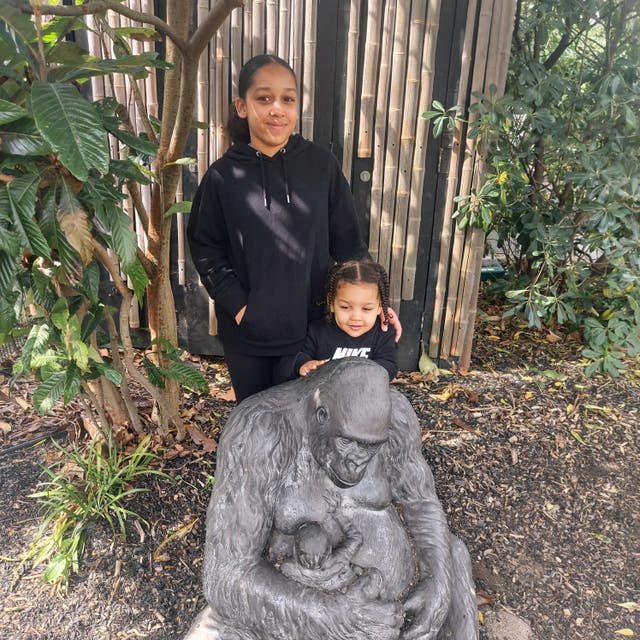 Kyra Hill (left) with a small child next to an ape statue