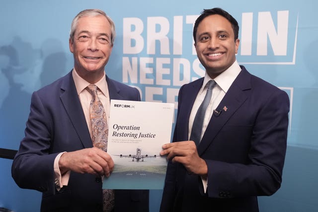 Nigel Farage and Zia Yusuf hold a leaflet