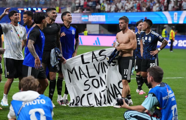 Argentina players hold up a banner with the words ‘Las Malvinas son Argentinas’ following victory over England
