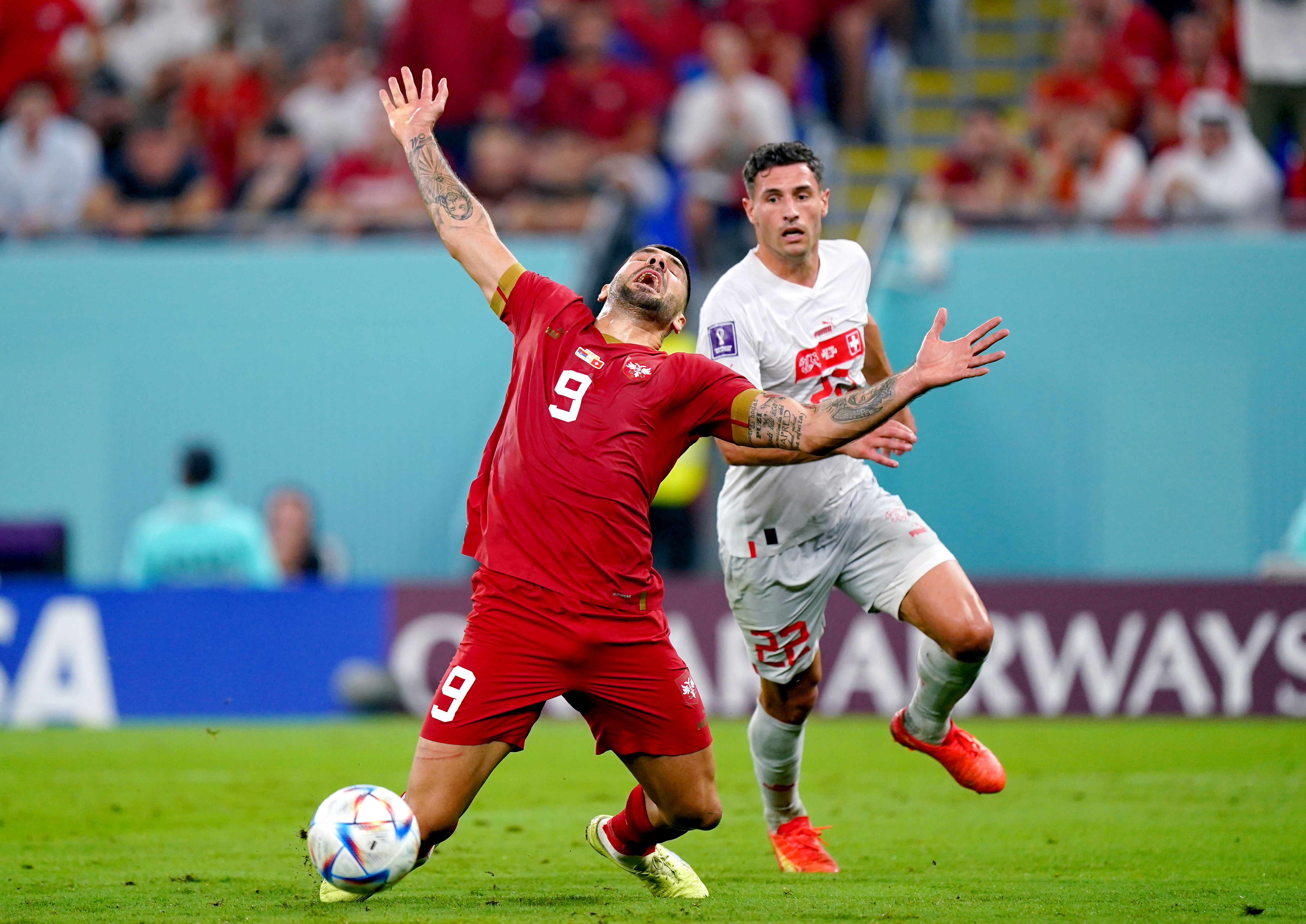 Serbia’s Aleksandar Mitrovic ) goes down whilst battling for the ball with Switzerland’s Fabian Schaer