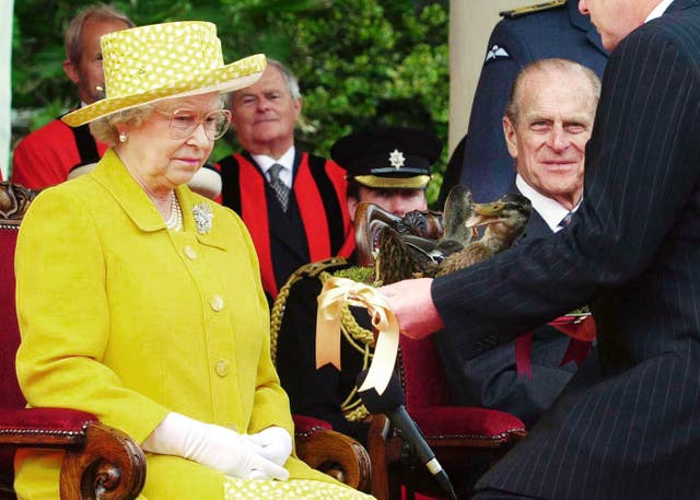 Elizabeth II is presented two dead female mallards on a silver platter in an act of homage by Steve Morgan, Seigneur of the Parish of Trinity on the island of Jersey in 2001