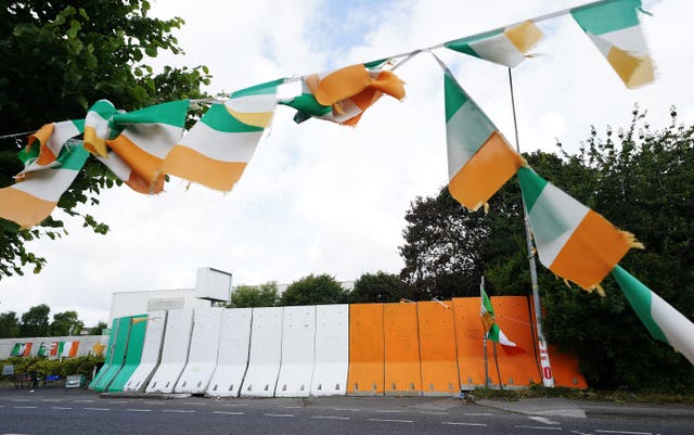 Orange, green and white concrete barriers erected at the entrance to the site of the former factory