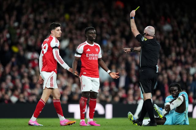 Kai Havertz, left, is shown a yellow card by referee Paul Tierney