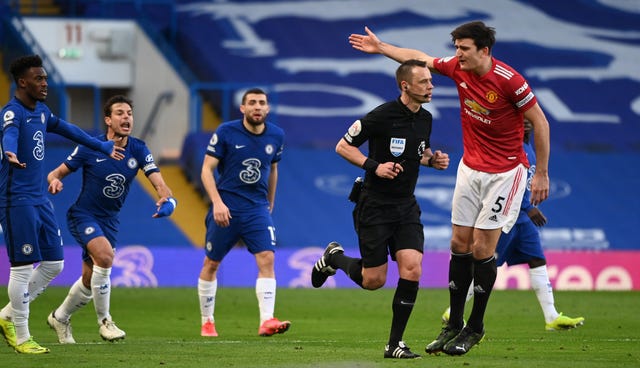 Chelsea players make their feelings known towards Manchester United's Harry Maguire after Stuart Attwell does not award a penalty after a VAR check