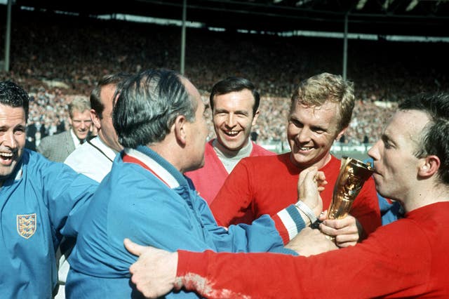 England captain Bobby Moore with manager Alf Ramsey as Nobby Stiles kisses the World Cup trophy