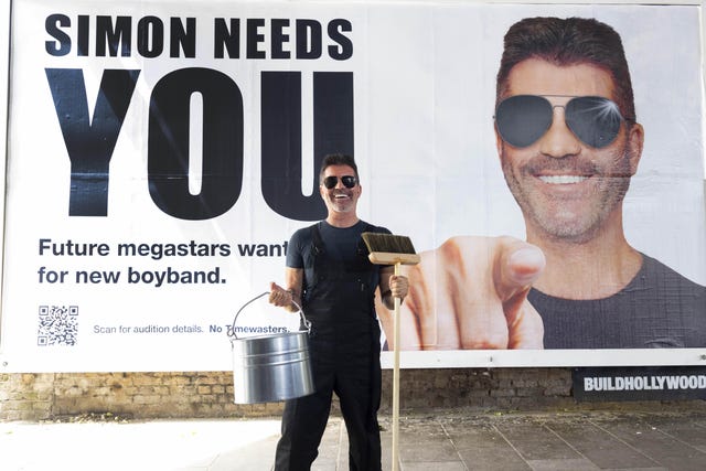 Simon Cowell next to a billboard appealing for the next ‘boyband sensation’