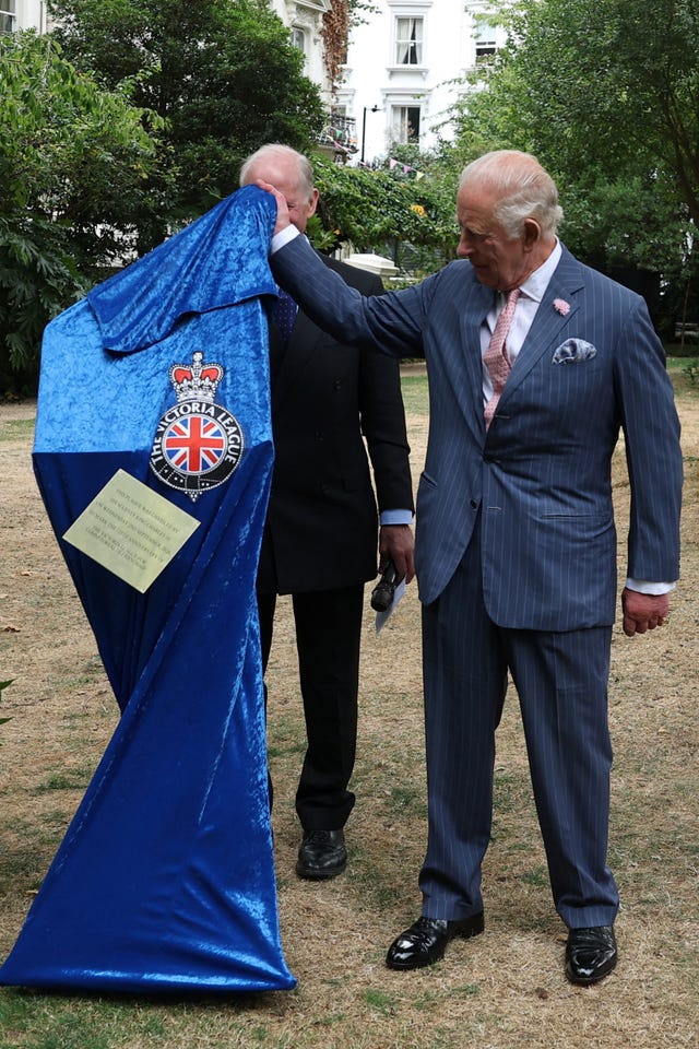 A commemorative plaque falls during an official unveiling by the King