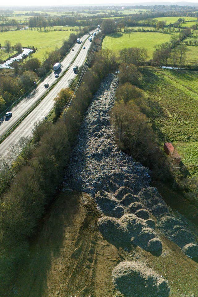 Dumped waste alongside the A34, with the River Cherwell in view at the far end of the mountain of rubbish