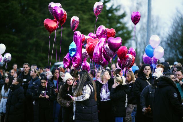People holding balloons at the vigil