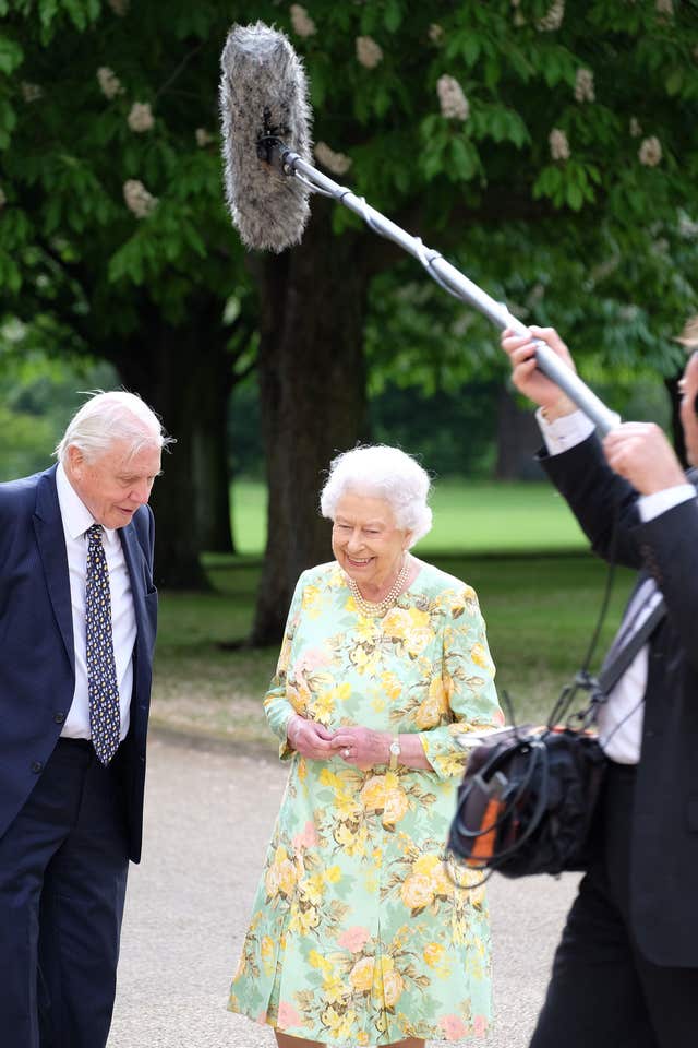 The Queen Elizabeth and Sir David Attenborough in the gardens of Buckingham Palace during filming of the Queen's Green Planet documentary. (ITV)