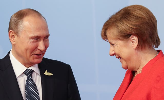 Vladimir Putin and Angela Merkel joke while at a G20 meeting
