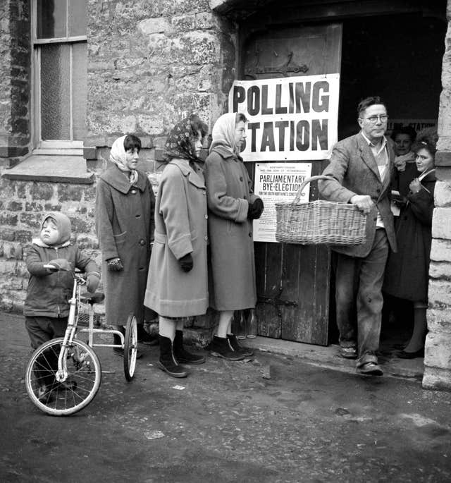 A baker with a basket on his arm leaves a polling station in Towcester after voting in the South Northamptonshire by-election on November 22 1962 (PA)