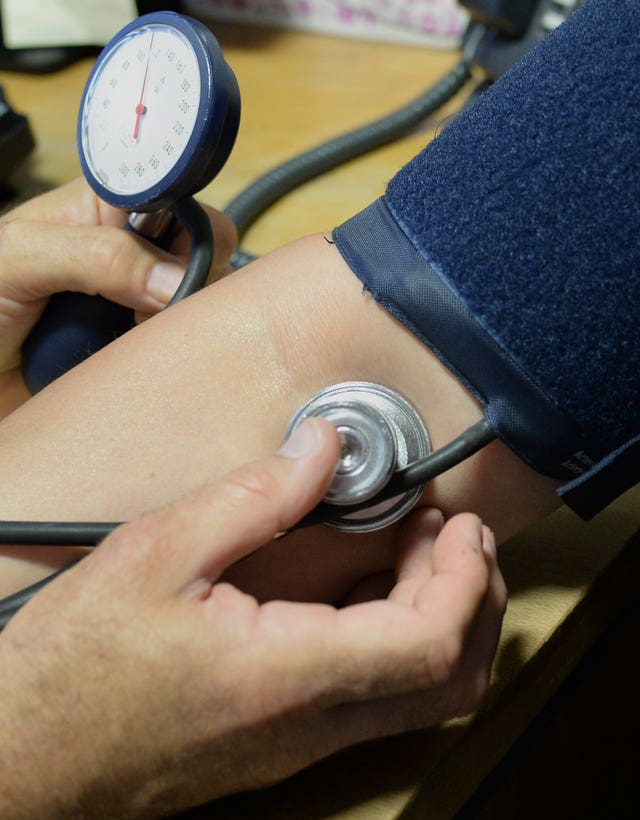 A doctor checking a patient’s blood pressure