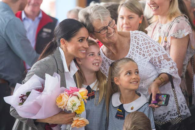 The Duchess of Sussex poses for a photo with members of the public at the naming and unveiling of a new Royal Flying Doctor Service aircraft