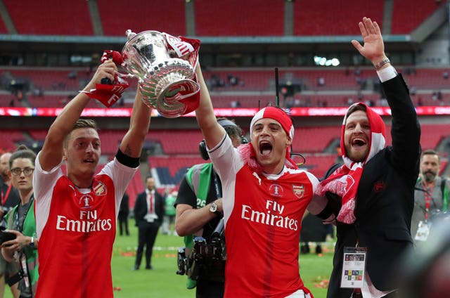Mesut Ozil, left, played in three of Arsenal's FA Cup final wins 