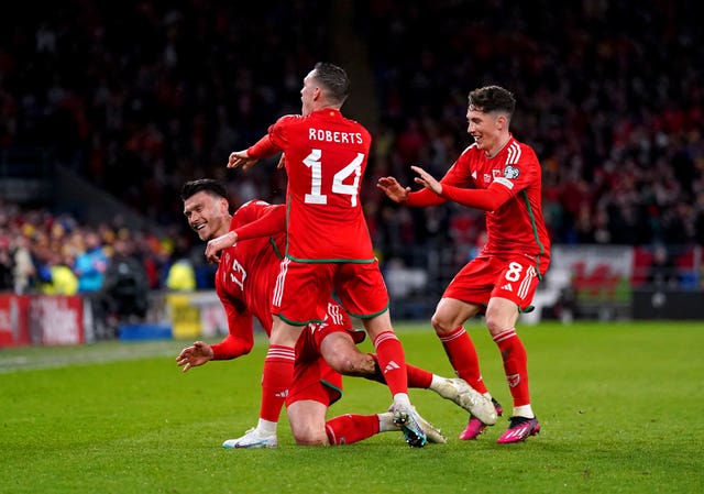 Kieffer Moore, left, celebrates his winning goal with Connor Roberts, centre, and Harry Wilson