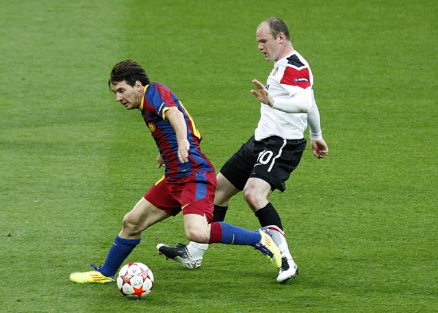 Barcelona's Lionel Messi holds off Manchester United's Wayne Rooney