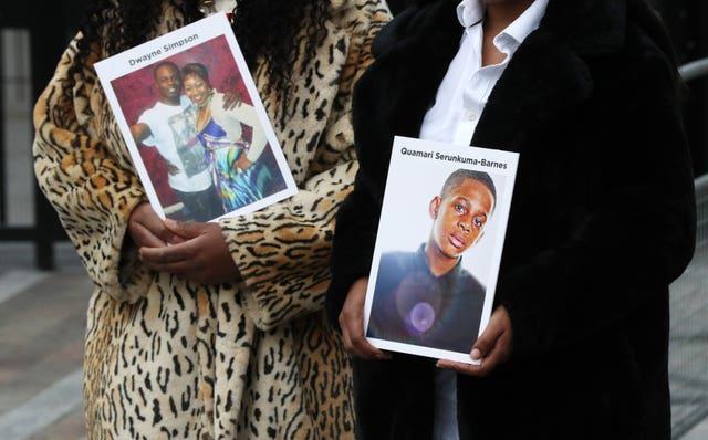 Lorraine Jones, left, and Lillian Serunkuma hold photographs of their sons
