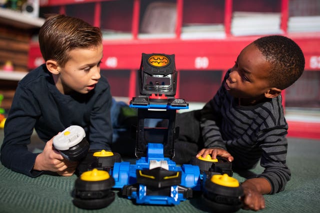 Charlie Bonnet-Davies, 10, and Mofe Akinsanmi, six, play with an Imaginext DC Super Friends Transforming Batmobile