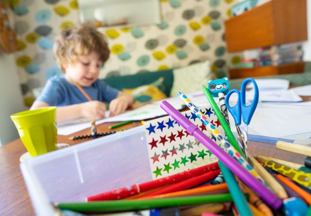 A child writing at a table