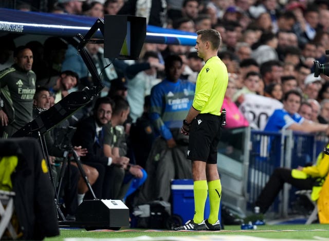 Referee Clement Turpin checks the VAR screen