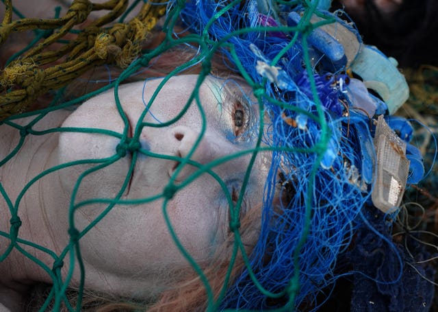 Activists from Ocean Rebellion covered in fishing nets demonstrate on the banks of the River Clyde as they ask Cop26 delegates to make bottom trawling/dredging a thing of the past