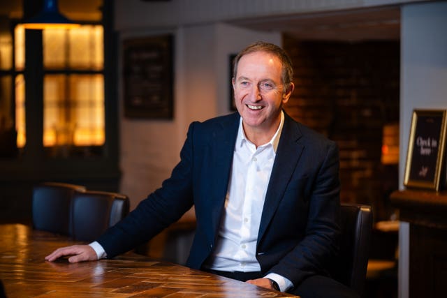 Nick Mackenzie smiling while sitting at a table in a pub