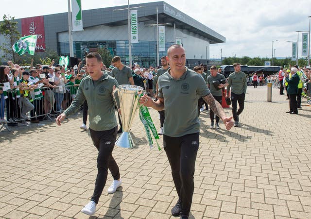 Celtic captain Scott Brown and Callum McGregor carry the Premiership trophy up the Celtic way