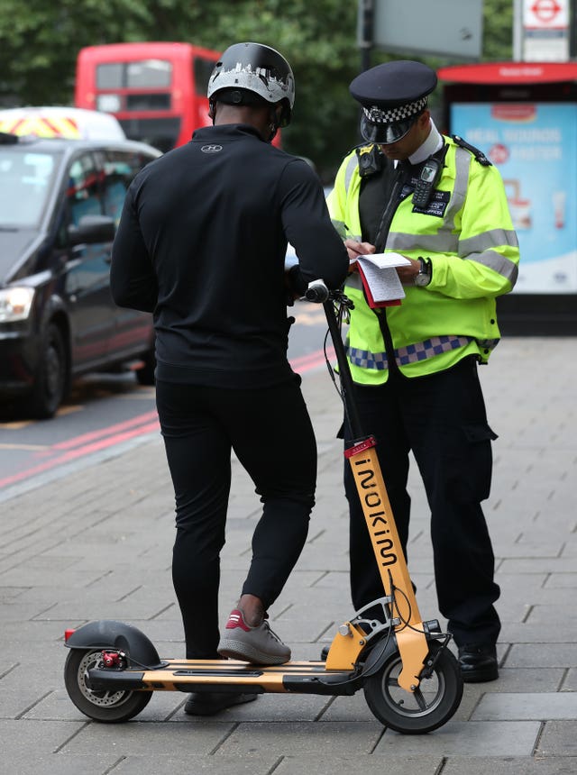 An e-scooter rider is given a warning by police (Yui Mok/PA)