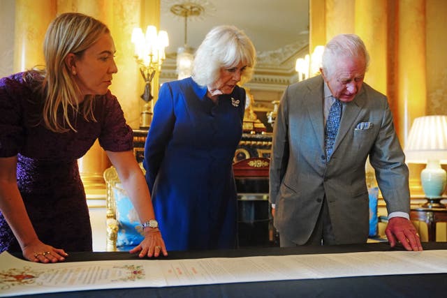 Charles and Camilla being presented with the Coronation Roll