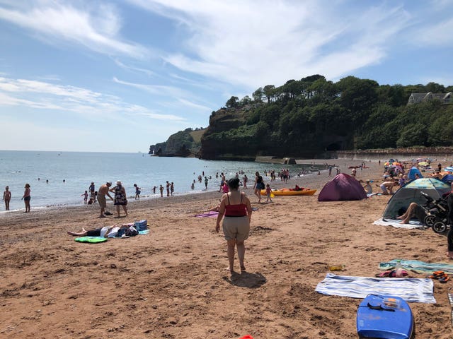 People enjoy the hot weather in Coryton Cove, Dawlish, Devon
