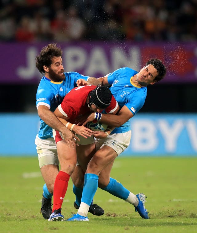 Wales' Leigh Halfpenny is tackled by two Uruguay players