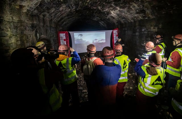 People watch a film while urban caving