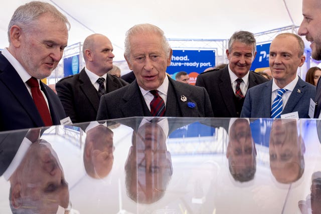 The King with various other men, with their heads reflected on glass in front of them