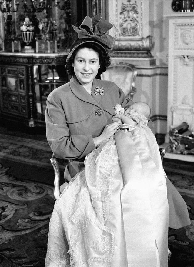 Princess Elizabeth holds her one-month-old son, Prince Charles, after his naming ceremony at Buckingham Palace in 1948 (PA)