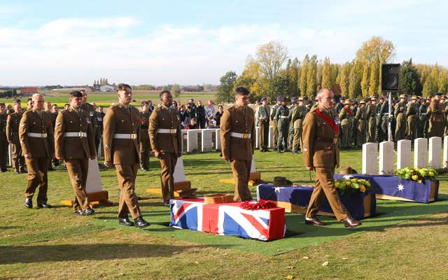 The coffin in laid down by soldiers