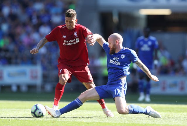 Roberto Firmino and Aron Gunnarsson tussle for the ball