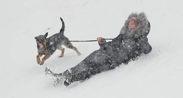 A woman and her dog enjoy the snow near Dublin (Niall Carson/PA)