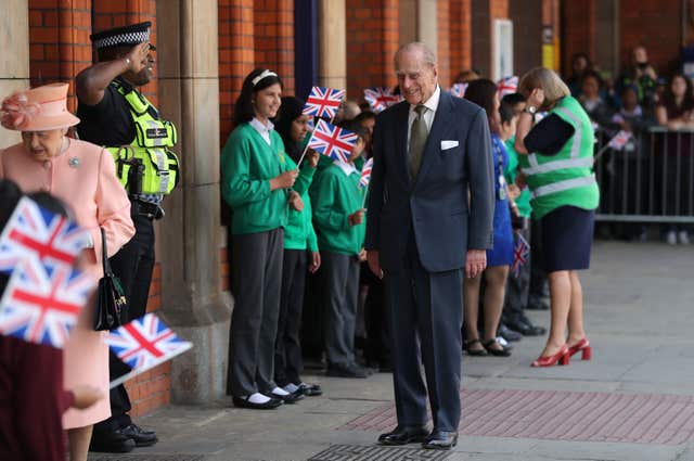 The Duke of Edinburgh is saluted by a policeman as he and the Queen arrive at Slough Station (Andrew Matthews/PA)