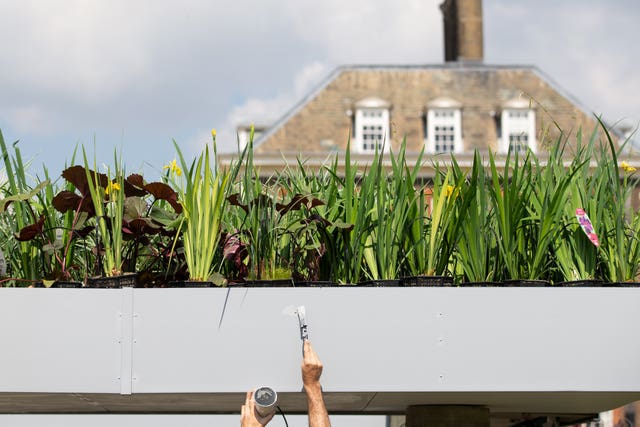 Finishing touches being applied to a flower show garden