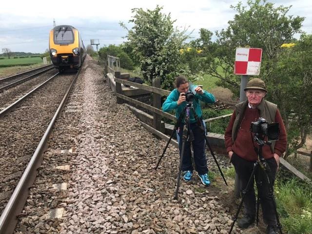 Two people standing next to a 125mph train line in Elford, Staffordshire to catch a close glimpse of Flying Scotsman (British Transport Police/PA)
