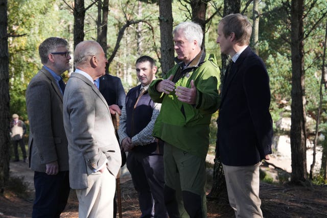Charles meeting a group of men in a woodland area