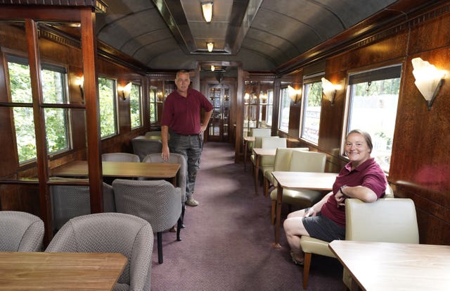 Simon and Diana Parums inside their full-size steam train with carriages, tracks and platform as they converted and restored Bassenthwaite Lake station in Keswick