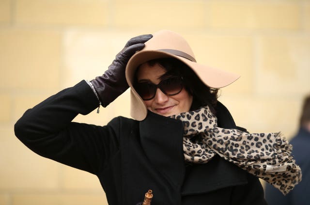 A female racegoer holds onto her hat during Ladies Day of the 2018 Cheltenham Festival at Cheltenham Racecourse (Steven Paston/PA)